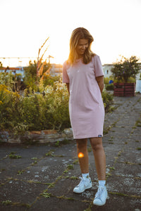 Model in bequemen canyonpinken T-Shirt Kleid steht im Sonnenuntergang
